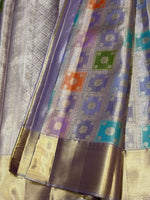 Load image into Gallery viewer, A close-up of a woven fabric textile with a lavender-purple body, metallic gold borders, and woven square motifs in purple, teal, green, and orange.

